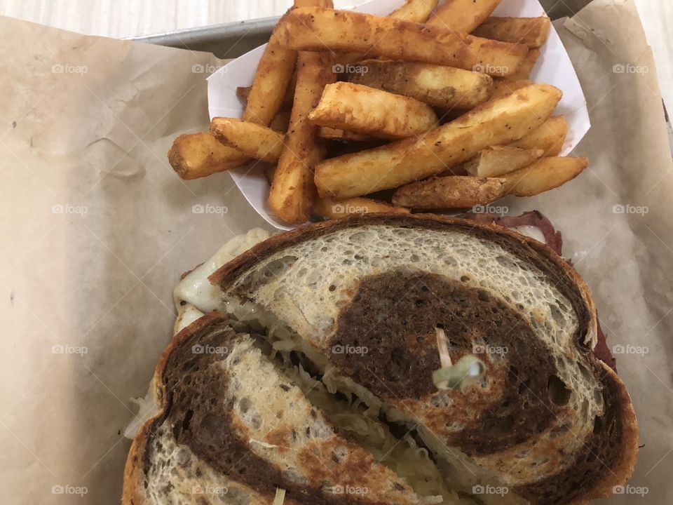 A delicious Reuben sandwich with fries