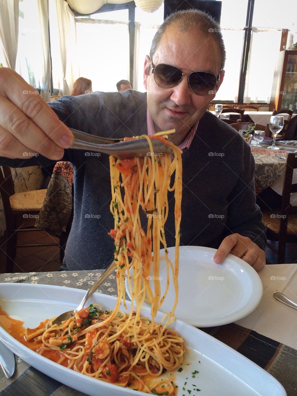 Happy man with noodles at the restaurant