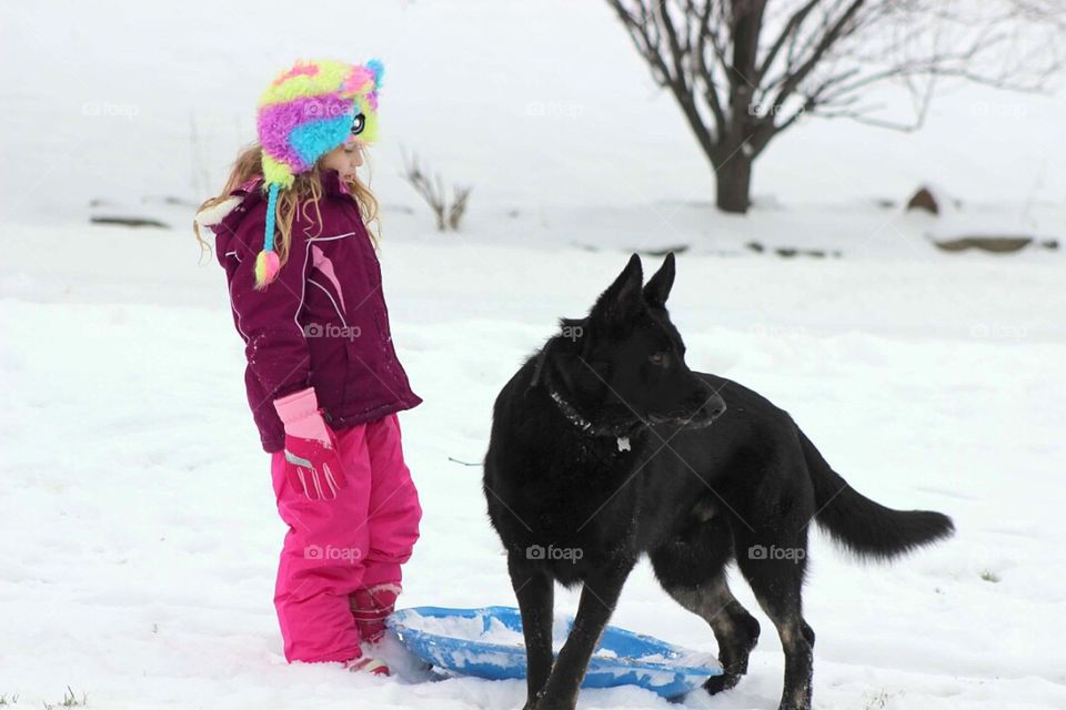 Girl and dog standing in snow
