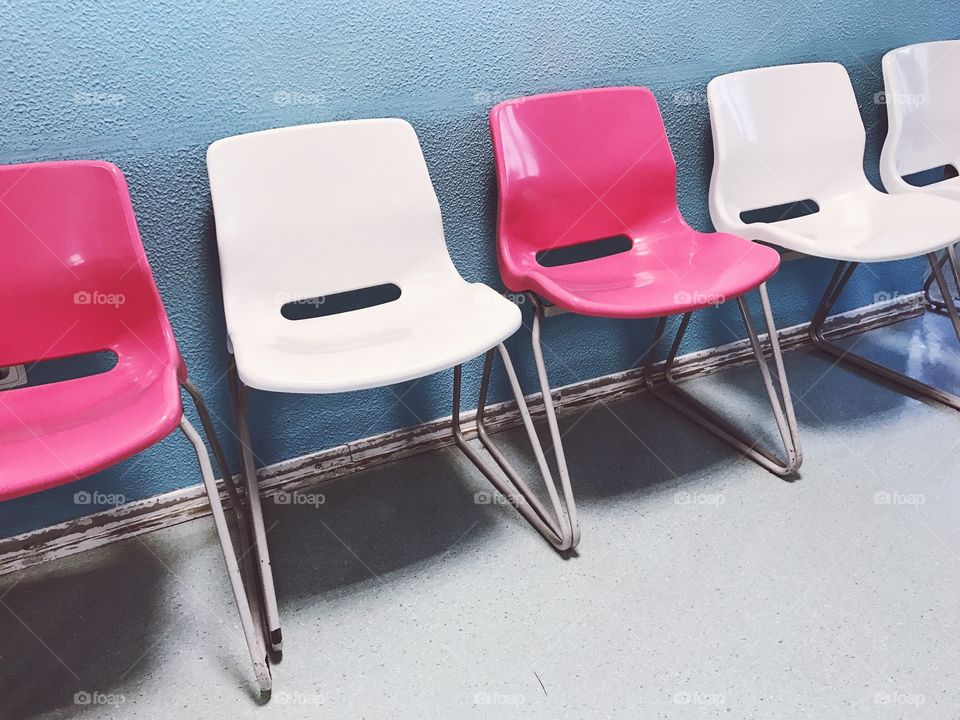 Empty chairs lined against wall