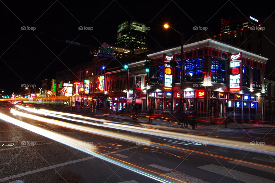 Night time exposure of downtown Nashville Tennessee broadway street with bars and country music venues showing neon lights