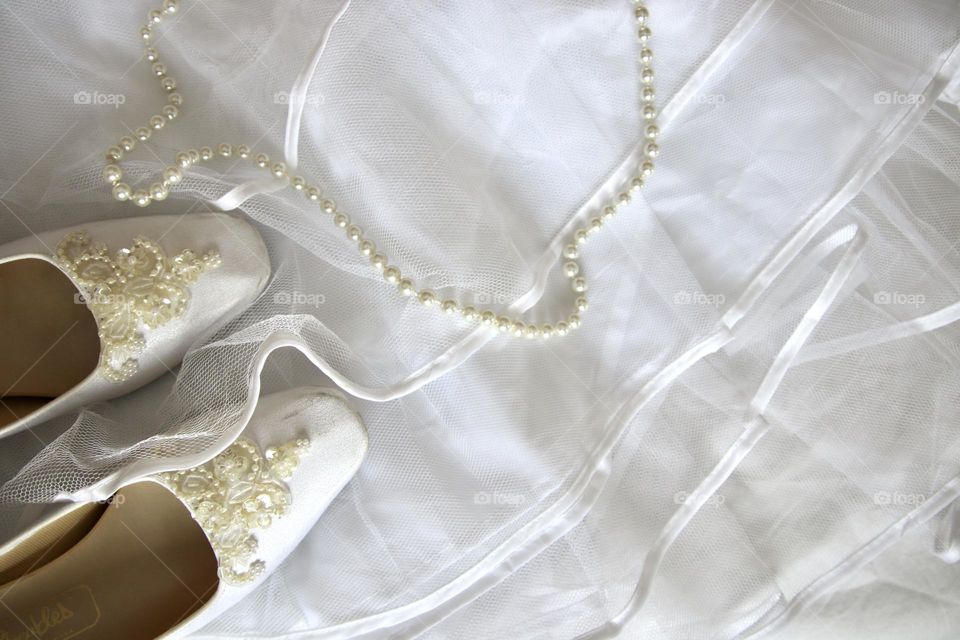 White pearls and wedding shoes over tulle skirt