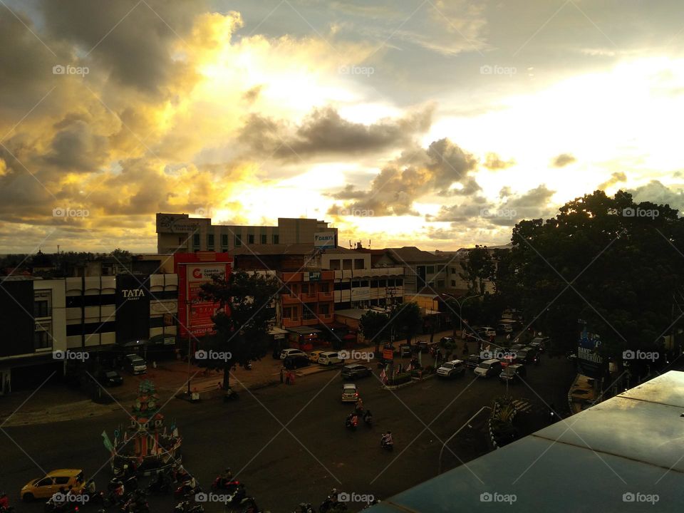 matahari mulai terbenam dari atas gedung berlantai 3