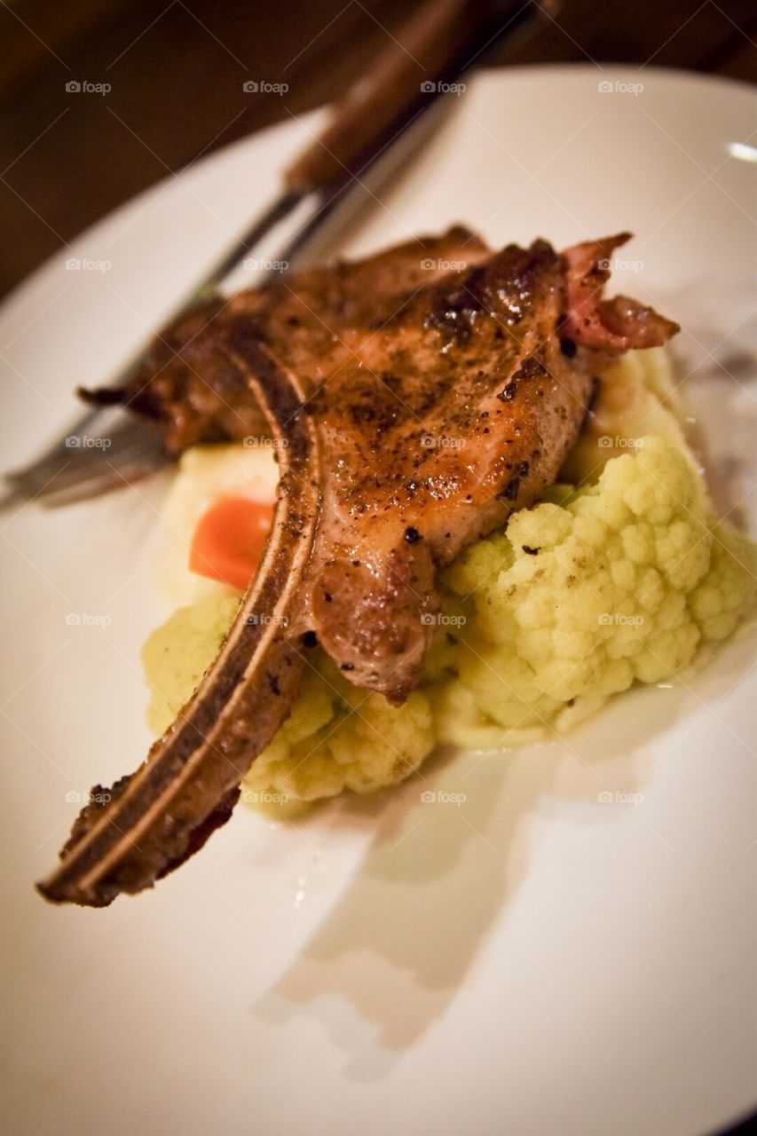 Mouth watering grill pork chop served with mash potato and vegetables