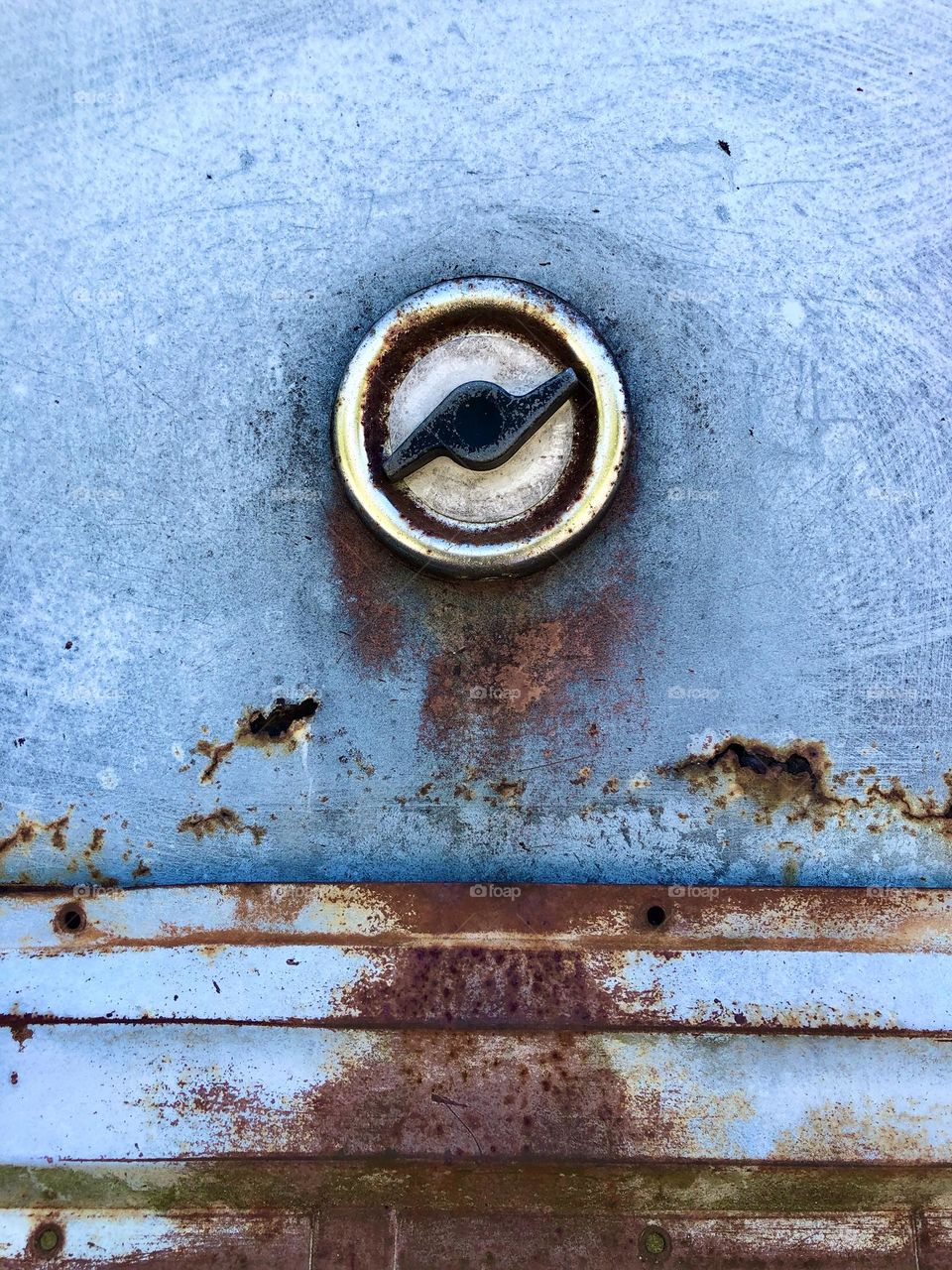 Vintage gas cap on rusting blue truck