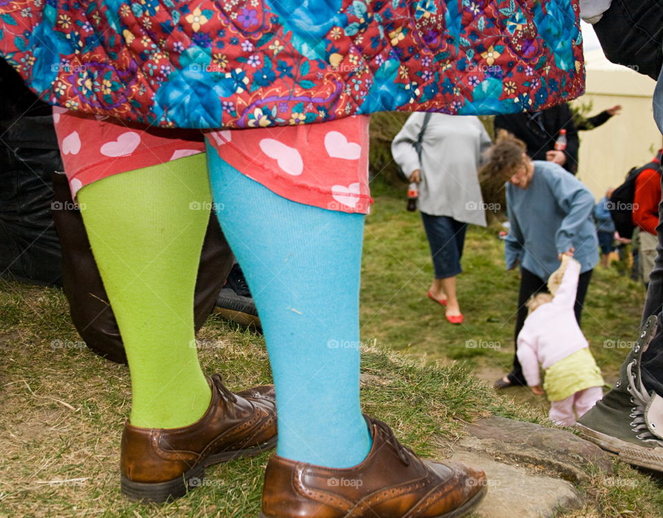 A crazy pair of feet in mismatched socks and comfy shoes, that clash spectacularly with the rest of the wearer’s highly patterned outfit - at a local festival in Hastings, UK. This image is inspired by the work of Martin Parr