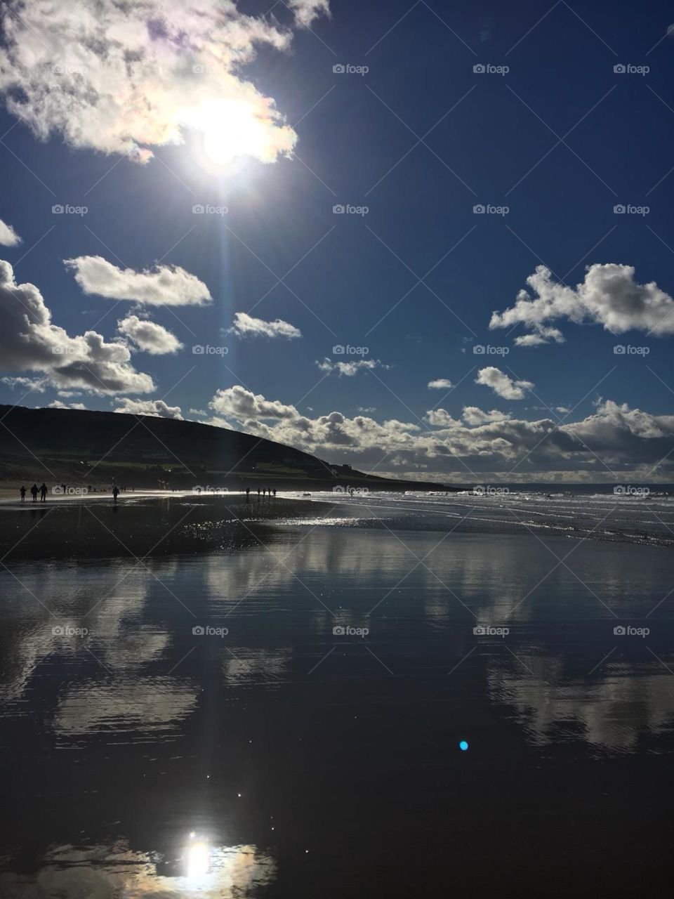 Beautiful autumn day in Croyde, Devon. Clouds captured as a reflection in the surf