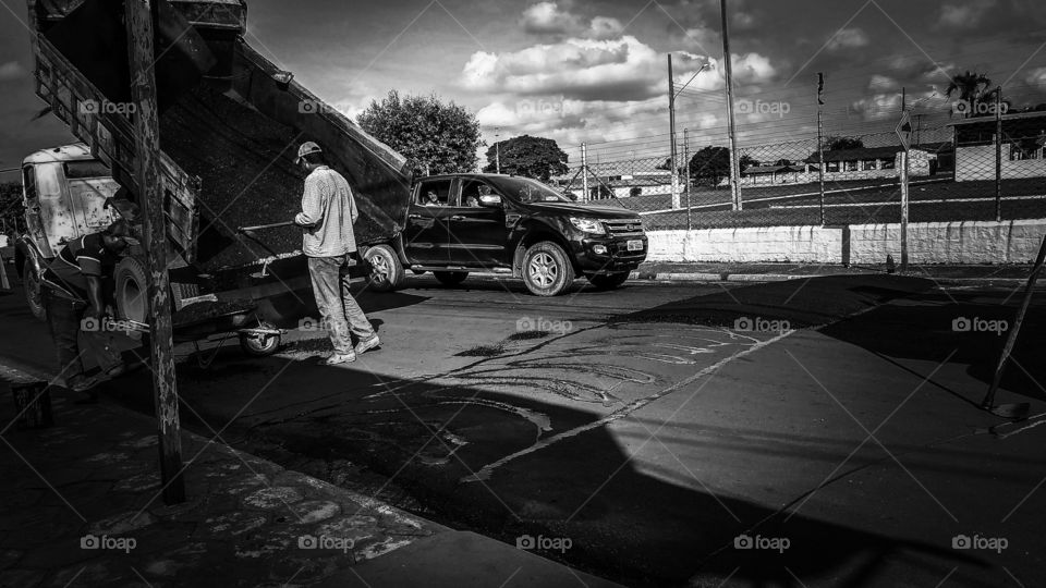 Homens trabalhando em asfalto. Prefeitura em obras.