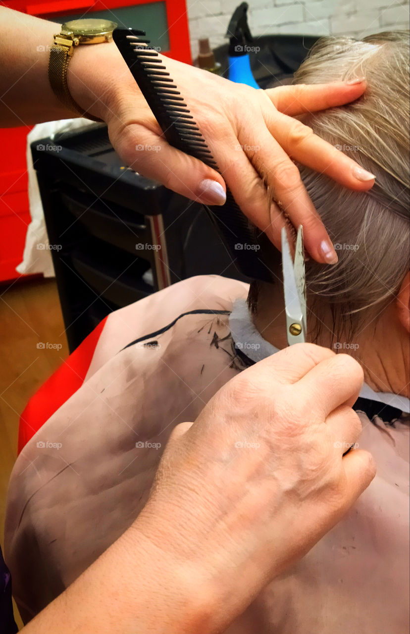 Scissors and calcination in the hands of a female hairdresser