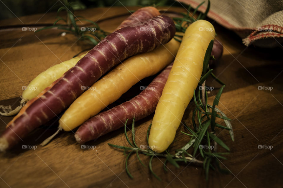 Colorful autumn harvest organic carrots on rustic wood cutting board 