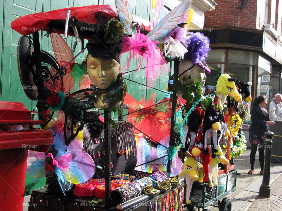 A lively fancy dress stall, selling, hats, masks, jewellery and other accessories 