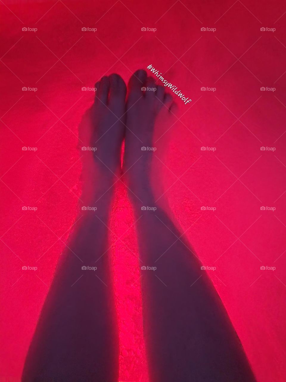 After a long day, feet resting in the red glow of the hot tub. Partially submerged to enjoy the full effects of the water and air.