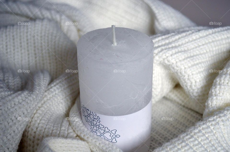 White candle on a knitted background