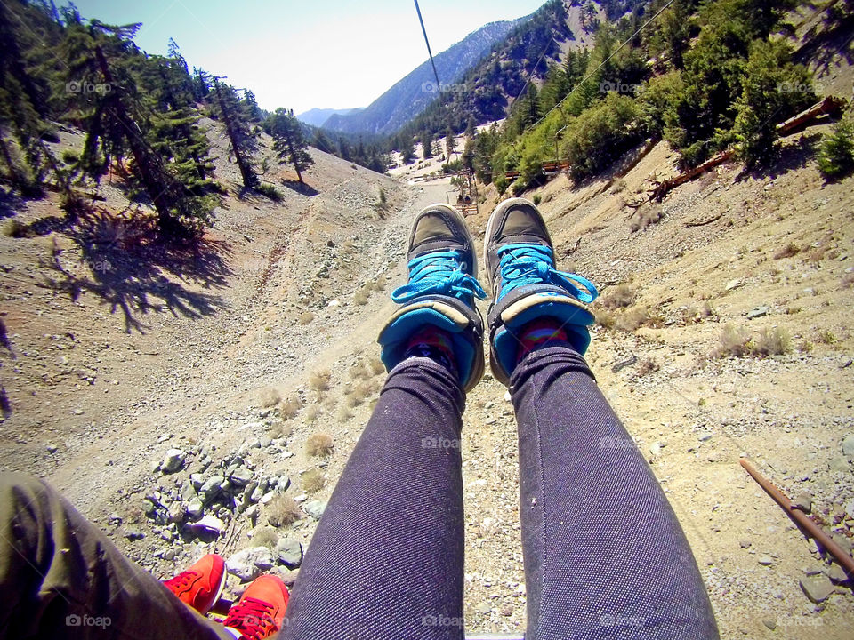 Feet hanging riding a chair lift