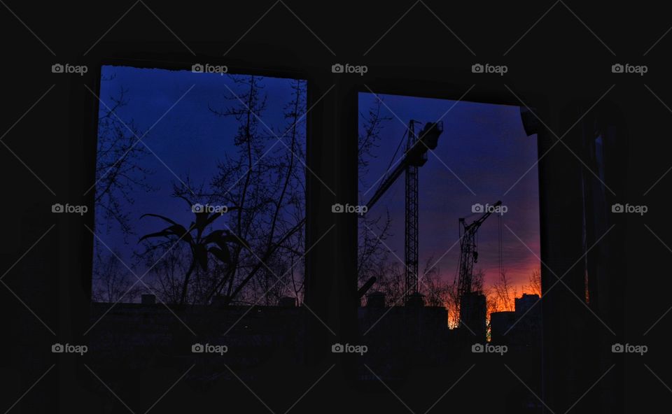 beautiful colour sunset window view evening and two cranes building