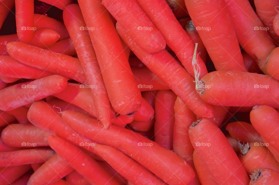 Many raw carrots on display for sale at a market in San Miguel de Allende, Mexico