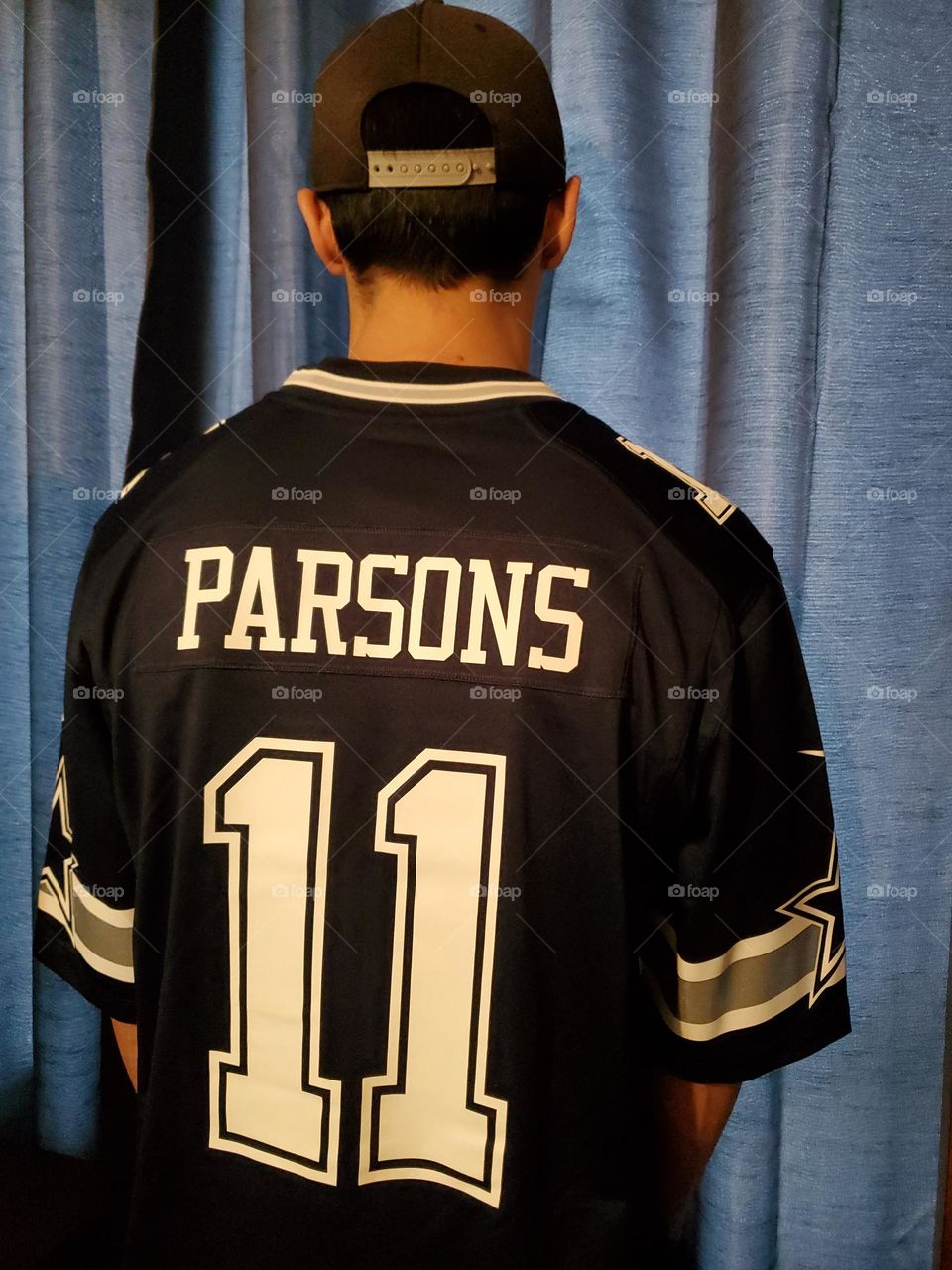 A man wearing a National Football League Dallas Cowboys' Parsons jersey.