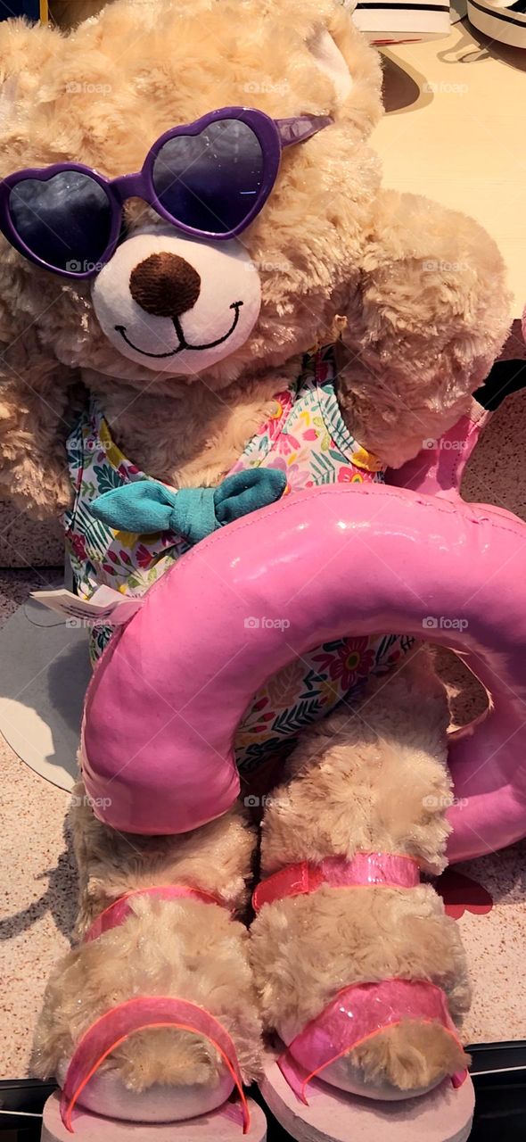 Summer ready teddy bear beach companion with Barbie style pink inner tube and purple sunglasses