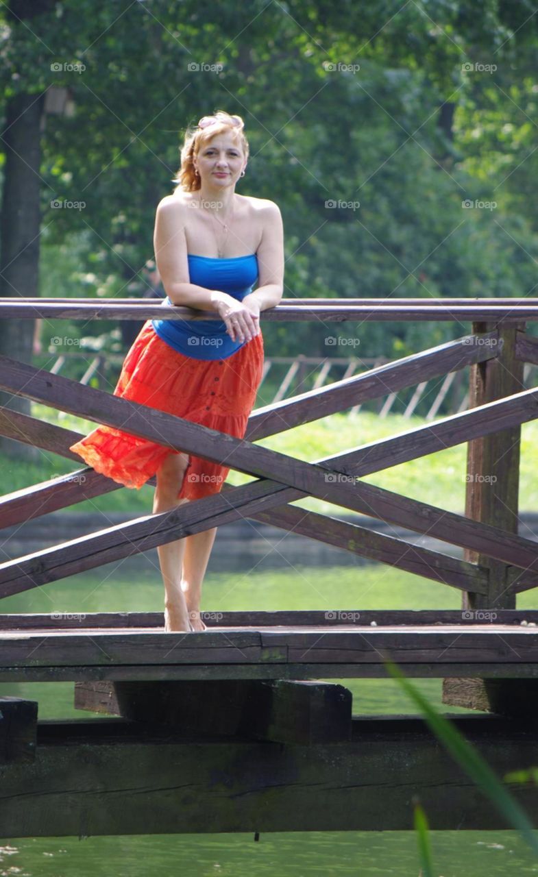 girl in red skirt standing on the bridge
