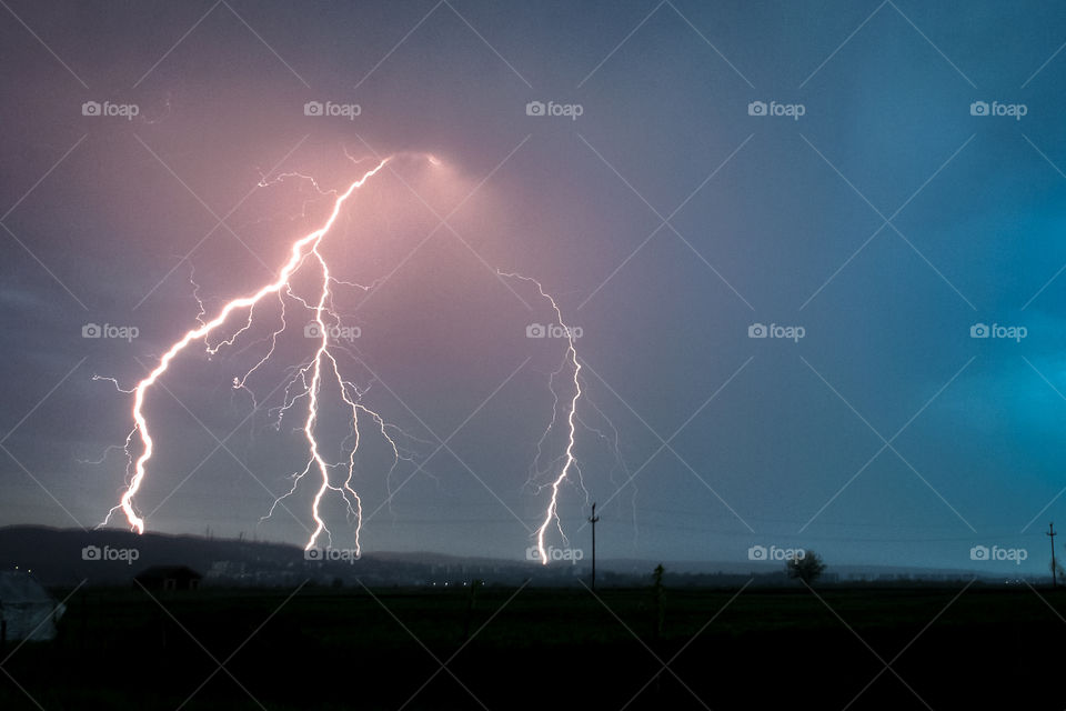 Bright lightning bolts over the city of Targu Mures in Transylvania, Romania during a severe spring thunderstorm.