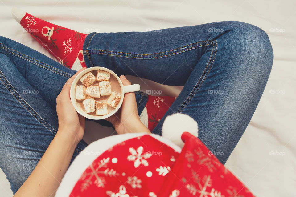 Hands holding mug of hot chocolate, top view