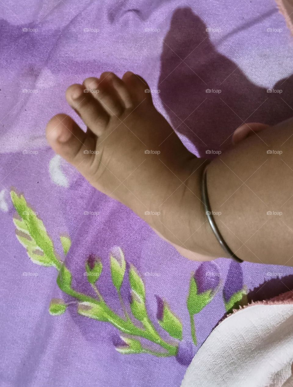 This beautiful ❤️😍 leg of two months baby girl 🐥😍. Baby is sleeping in her bed and playing joyfully with her toys!!🪀🧸