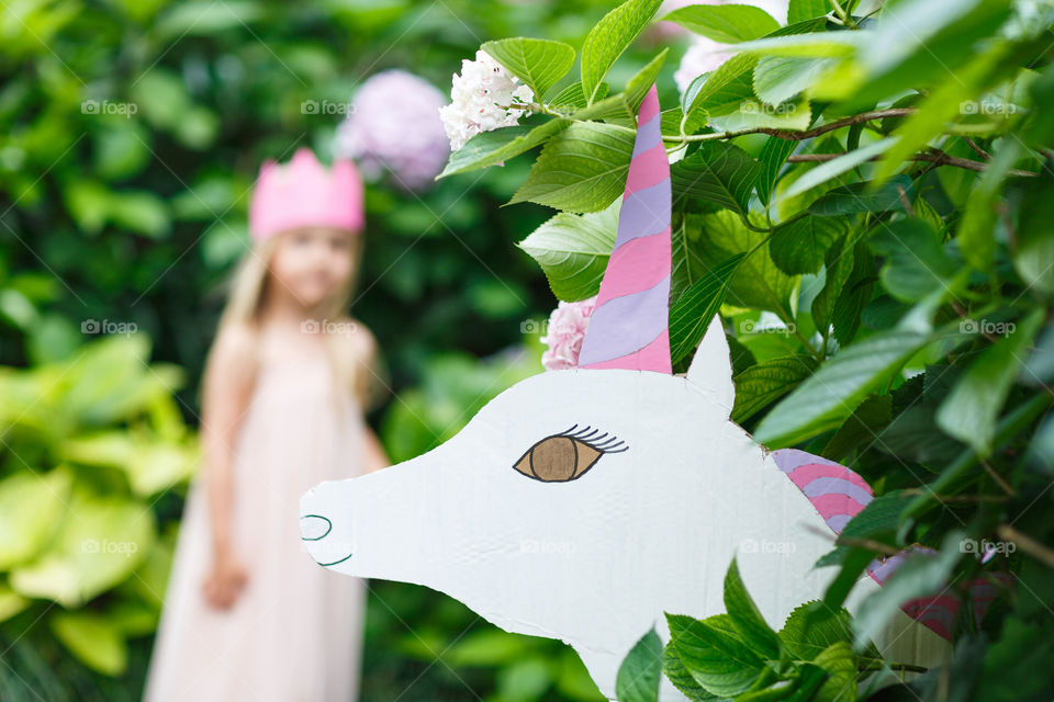 Unicorn in summer floral garden 