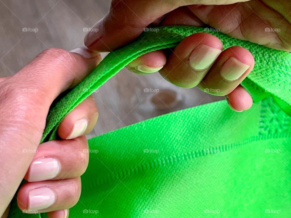 A person holding a green bag 