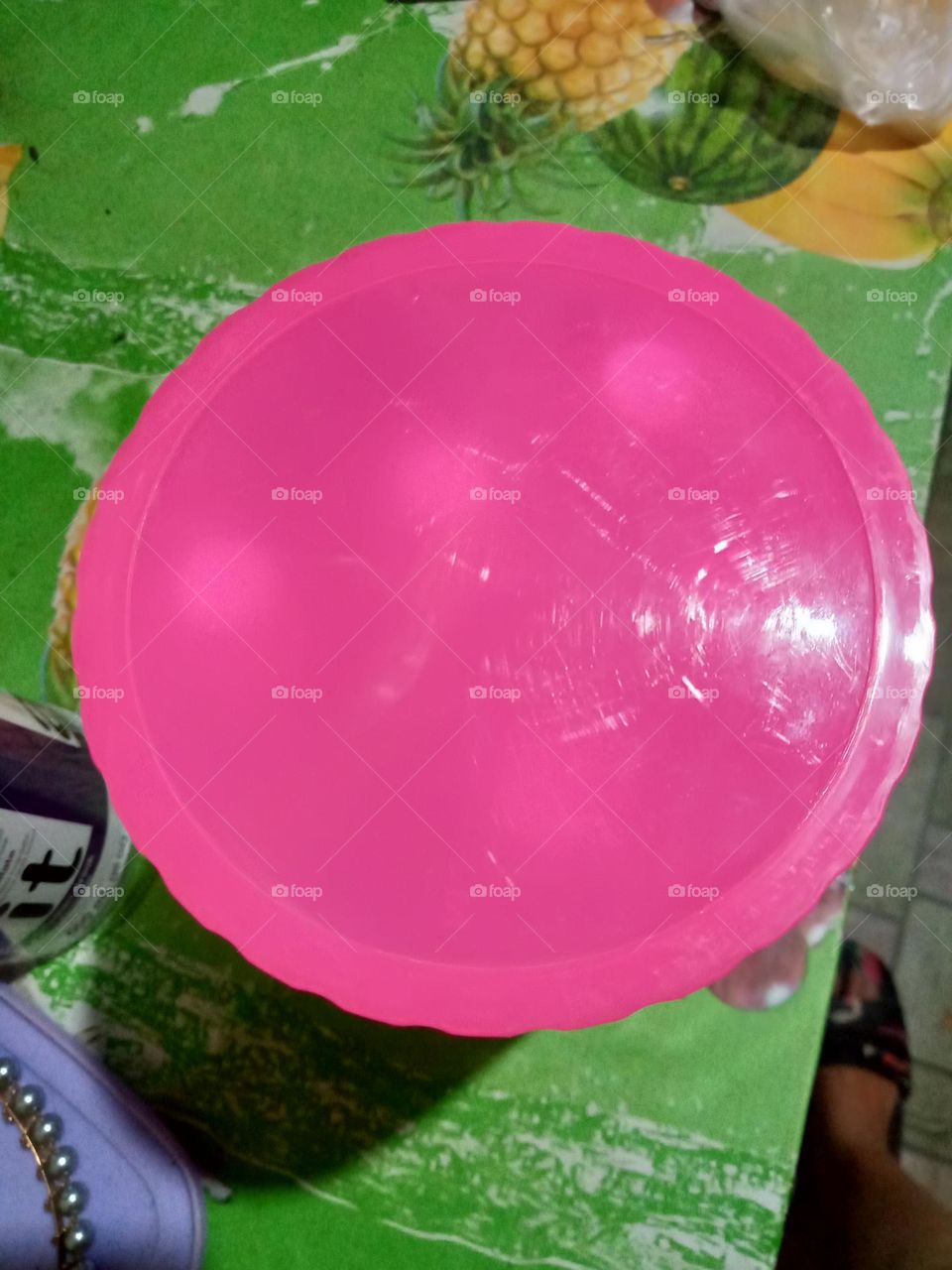 Plastic pink cover, shiny with small round  white holes underneath