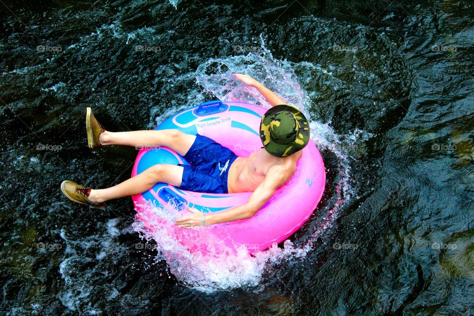 Boy on inflatable ring floating in river