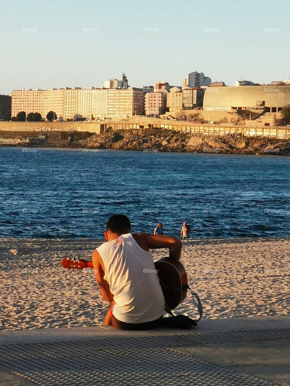 The sun is in the beach and the  Spanish guitarmen