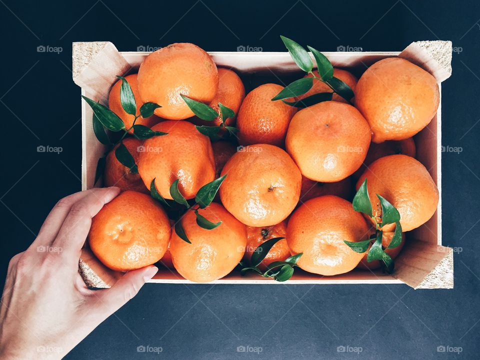 A person holding orange in hand