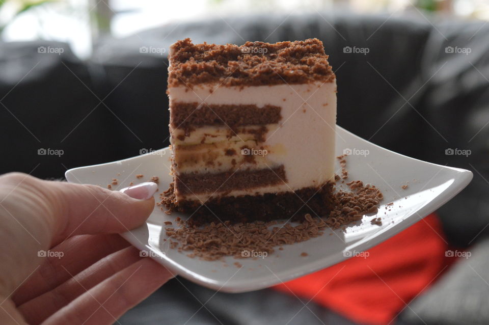 Person's hand holding cake slice