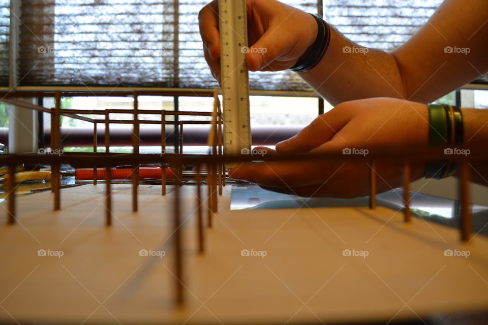 Architecture student measuring a model