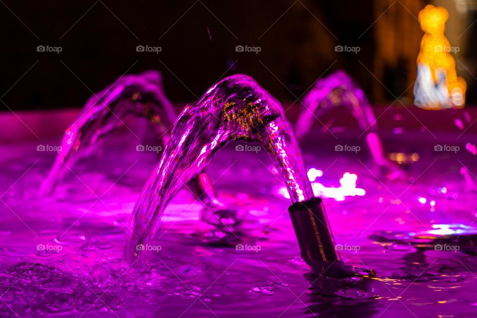 Fountain water colored by magenta lights