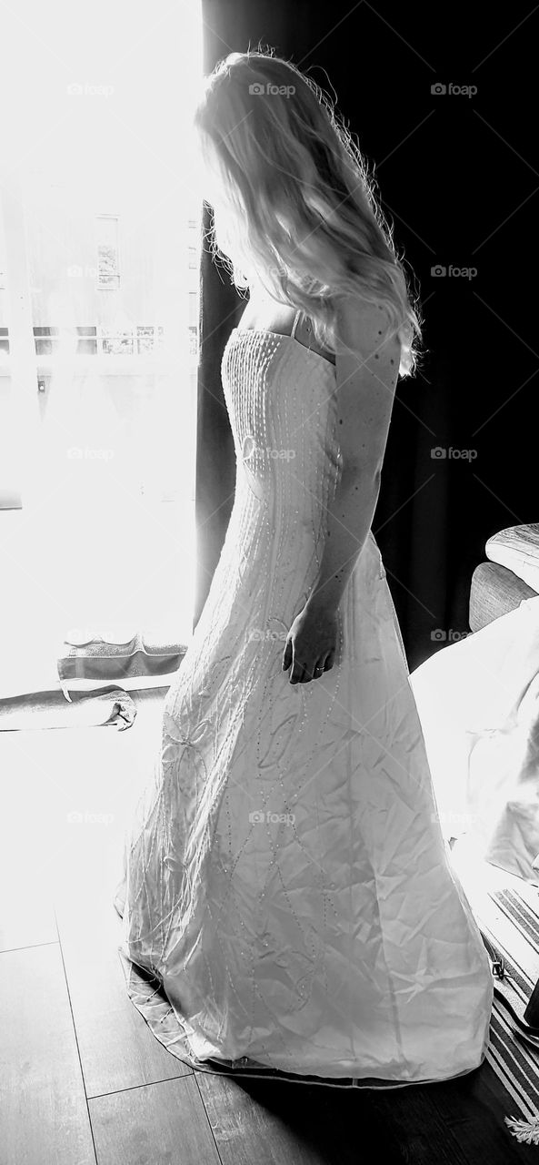 beautiful black and white picture from a young woman woth ling blond hair in a bridal dress with diffuse light