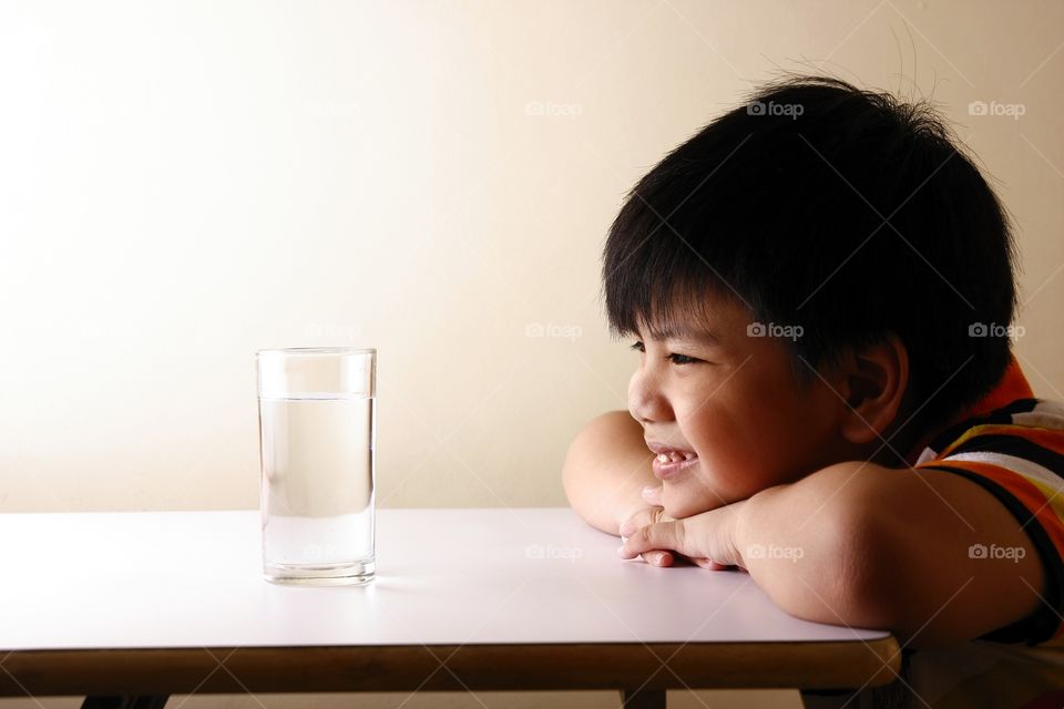 young boy looking at a glass of water