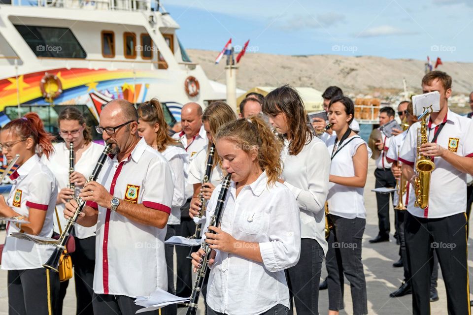 Young and old people from a local orchestra playing instruments in the street of a seaside town of Pag, Croatia