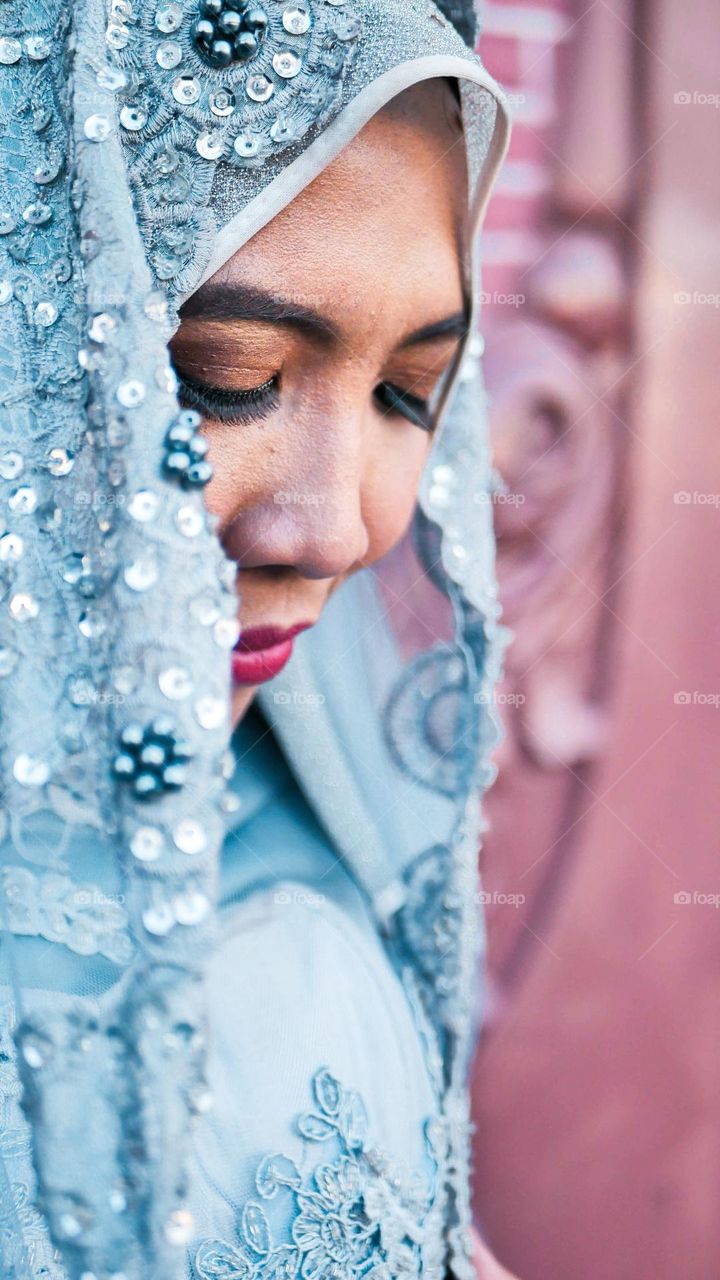 Portrait of young and beautiful Asian muslim woman wearing silver robe with matching hijab and headscarf, for the wedding.