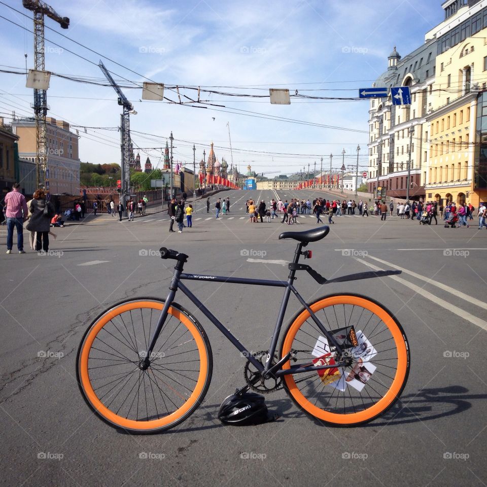 Grey brakeless fixie bike with orange wheels standing on one of the streets of Moscow, Russia