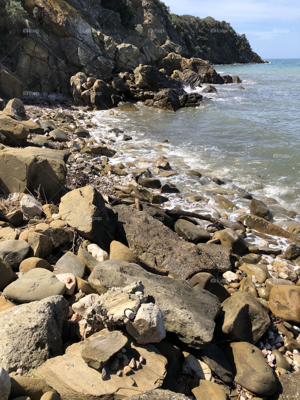 Rocks and stones beach and blue sea and sky 