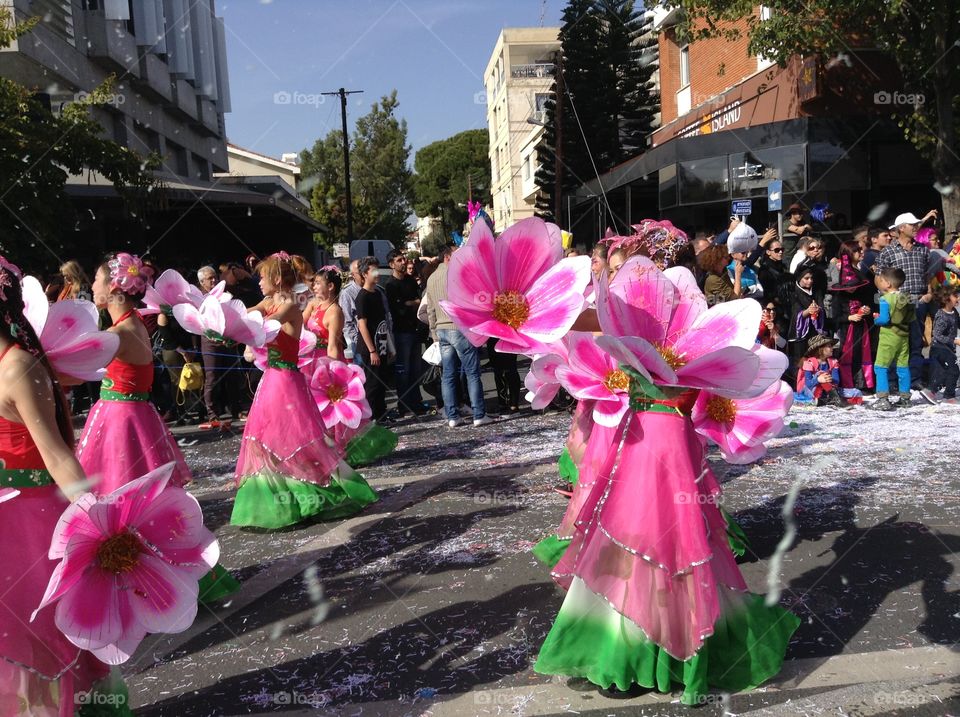Women dressed as pink flowers in carnival parade.