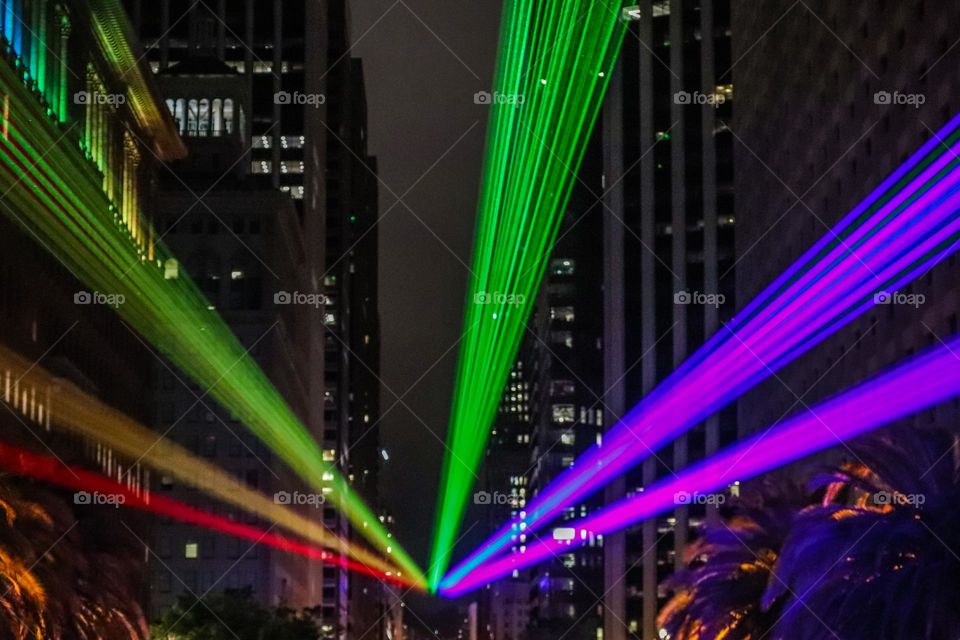 San Francisco Pride 2023 laser light display of the pride flag colors illuminating the sky in front of the Ferry Building on the Embarcadero looking down market street 