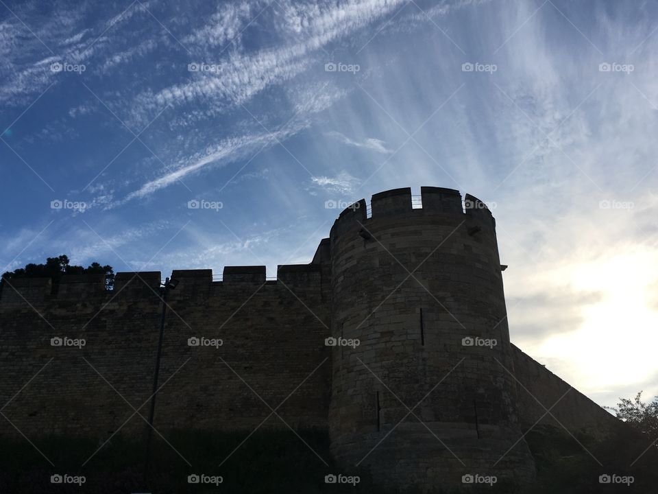 Exterior view of a tower at Norman-built Lincoln Castle on the north side with blue summer sky just before sunset 