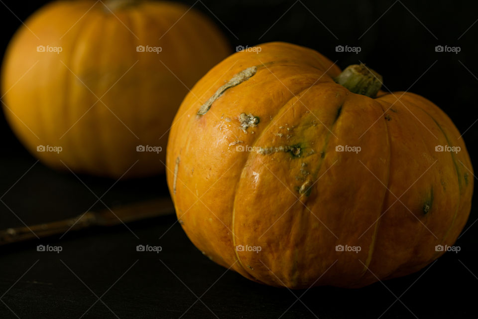Two pumpkins. Dark photo.