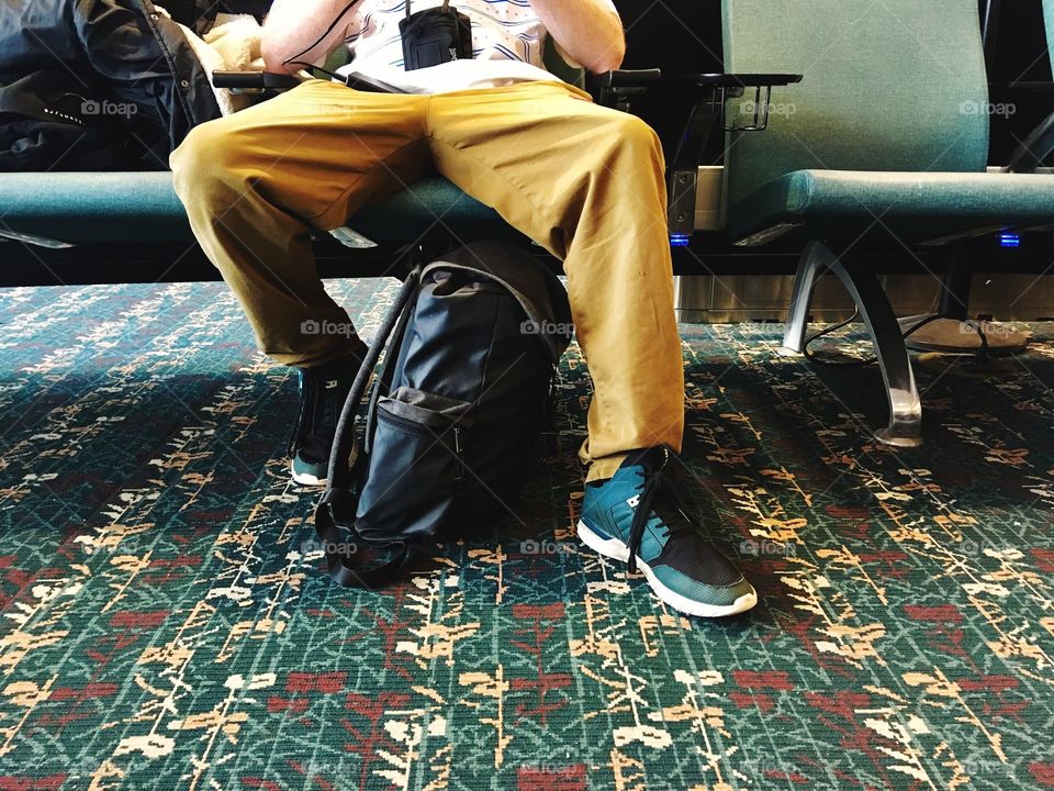 Young man waiting at the airport in casual clothes.