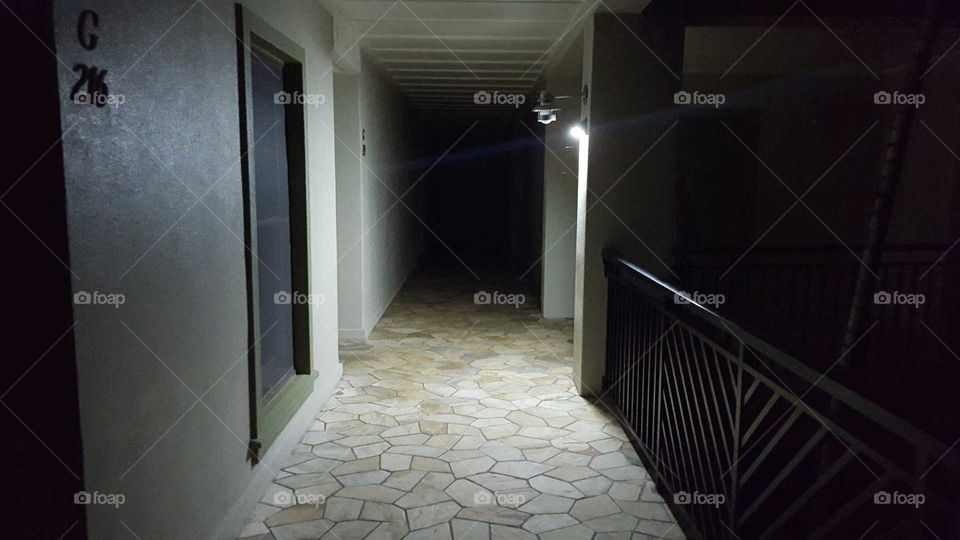 dimly lit hallway going progressively dark.