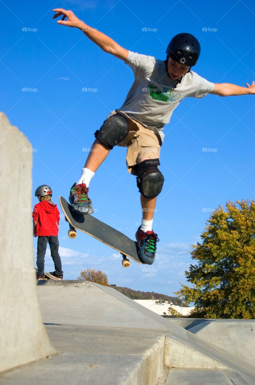 Skateboarder throwing tricks off a small ramp