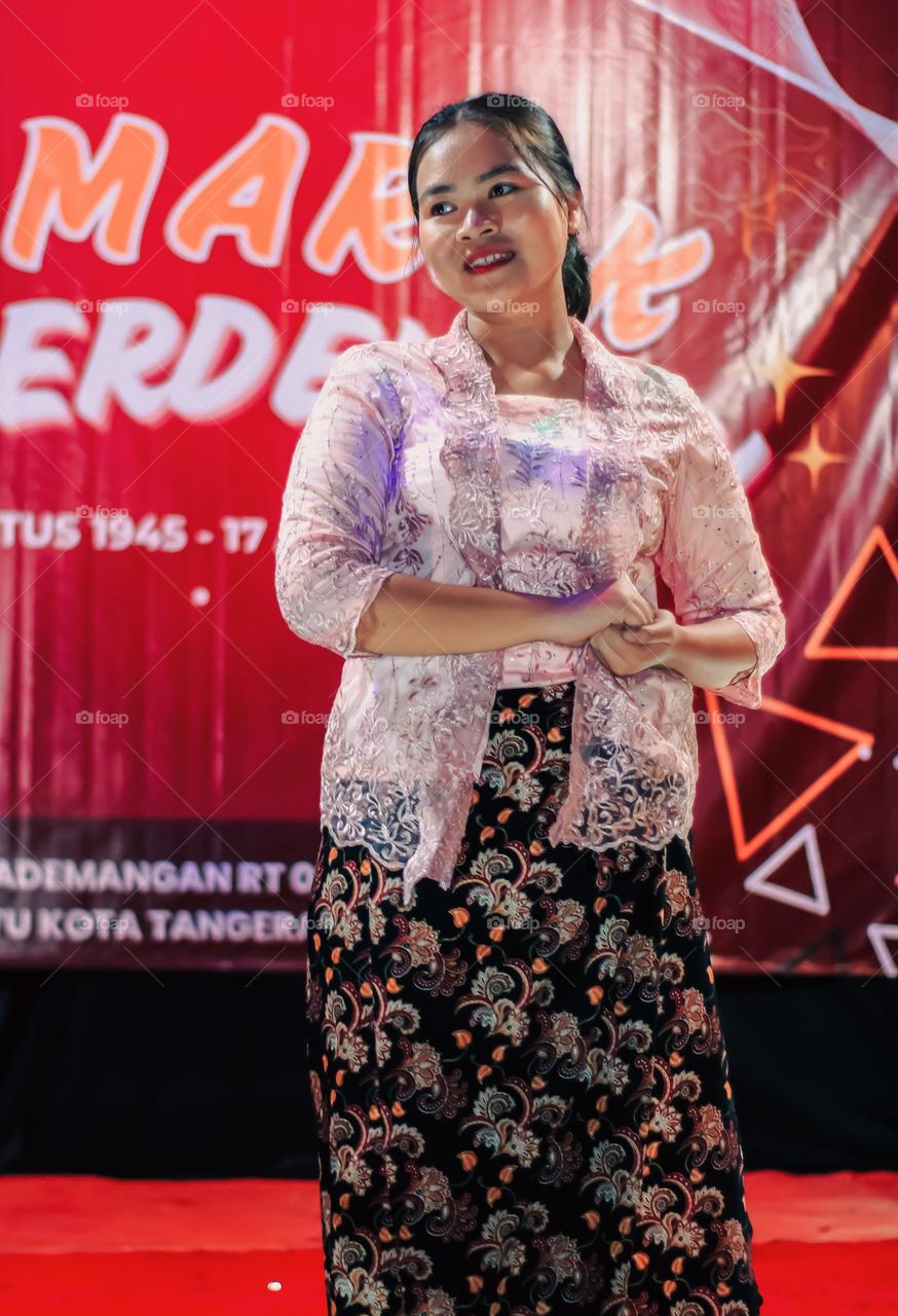 Portrait of a woman wearing a kebaya standing on stage