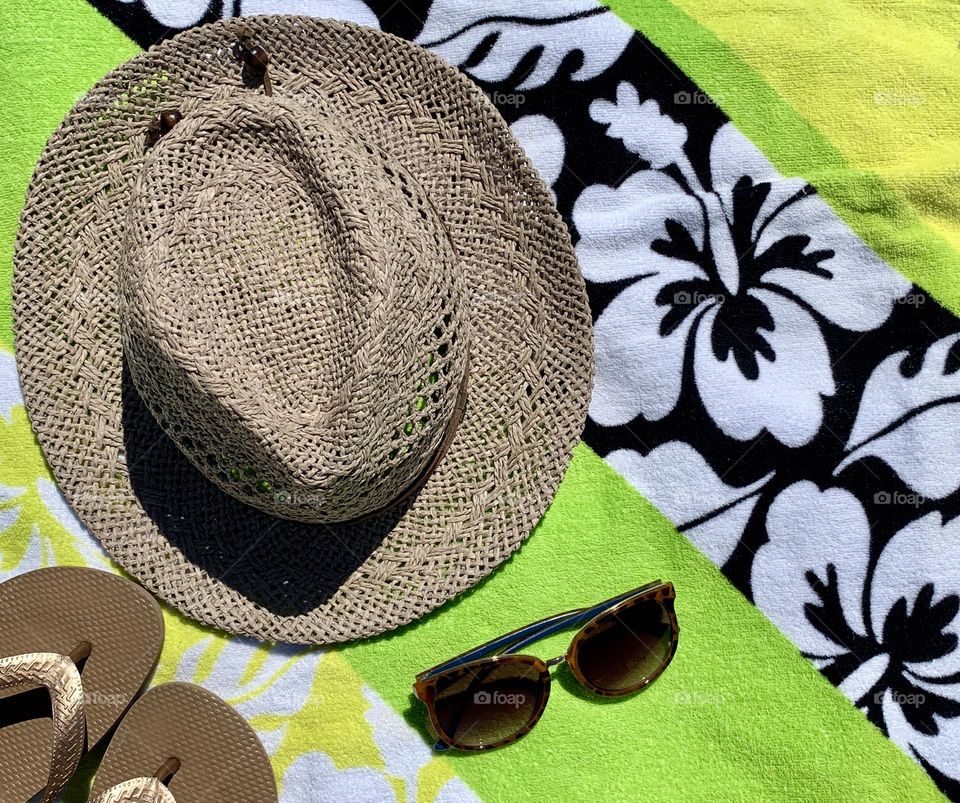 Hat, sleeper and sunglasses with colorful towel background 